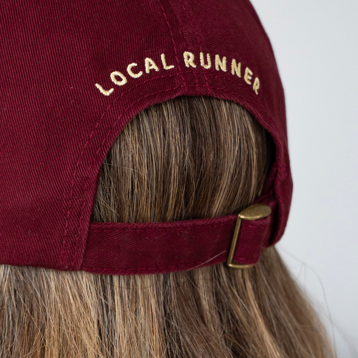 A Maroon cap with 'LOCAL RUNNER' embroidery