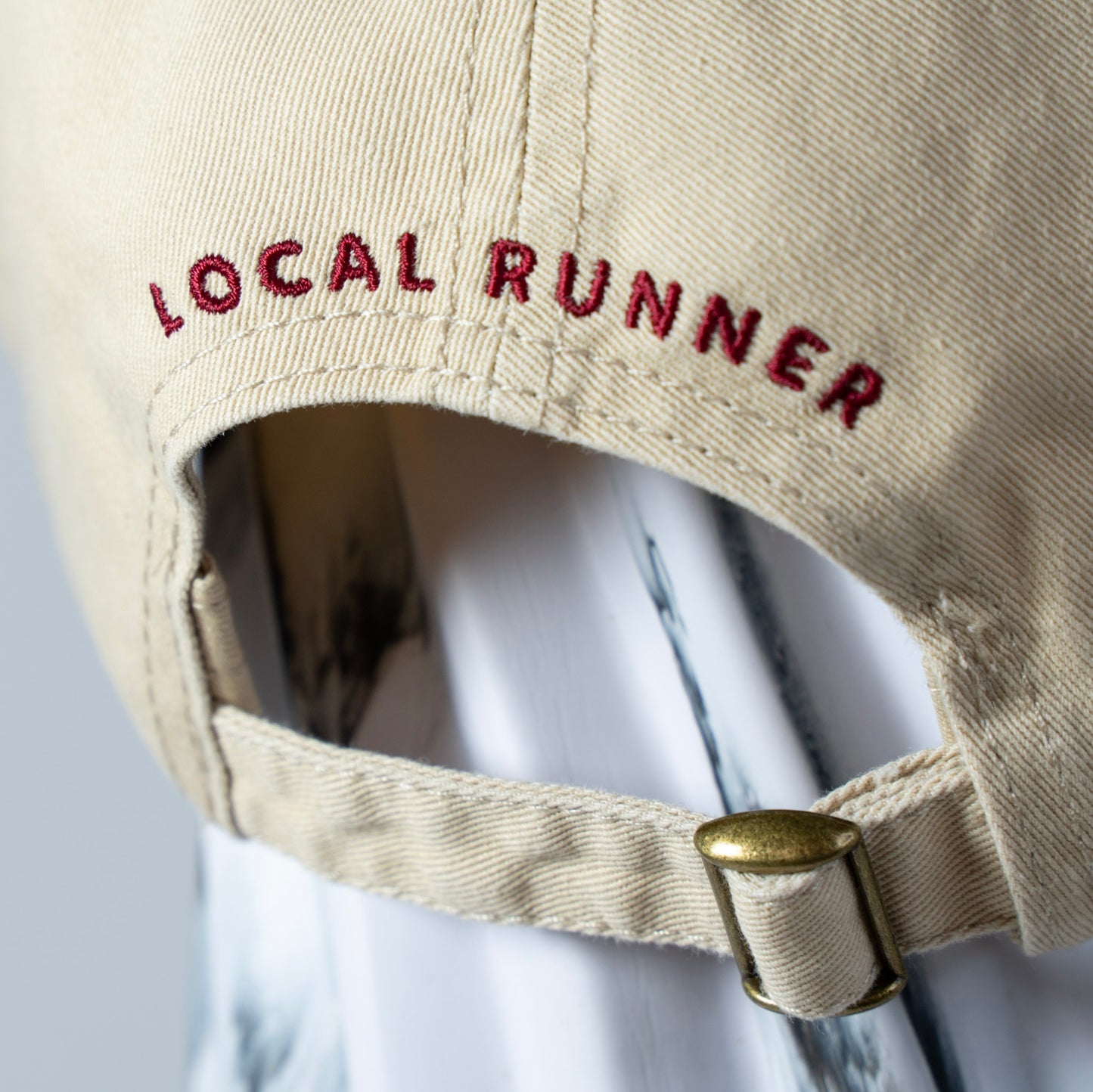 A Beige cap with 'LOCAL RUNNER' embroidery