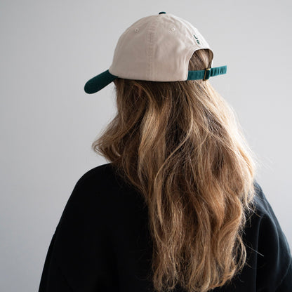 A beige cap with green bill with LR logo embroidery