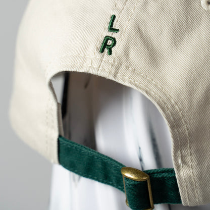 A beige cap with green strap and 'LR' logo embroidery