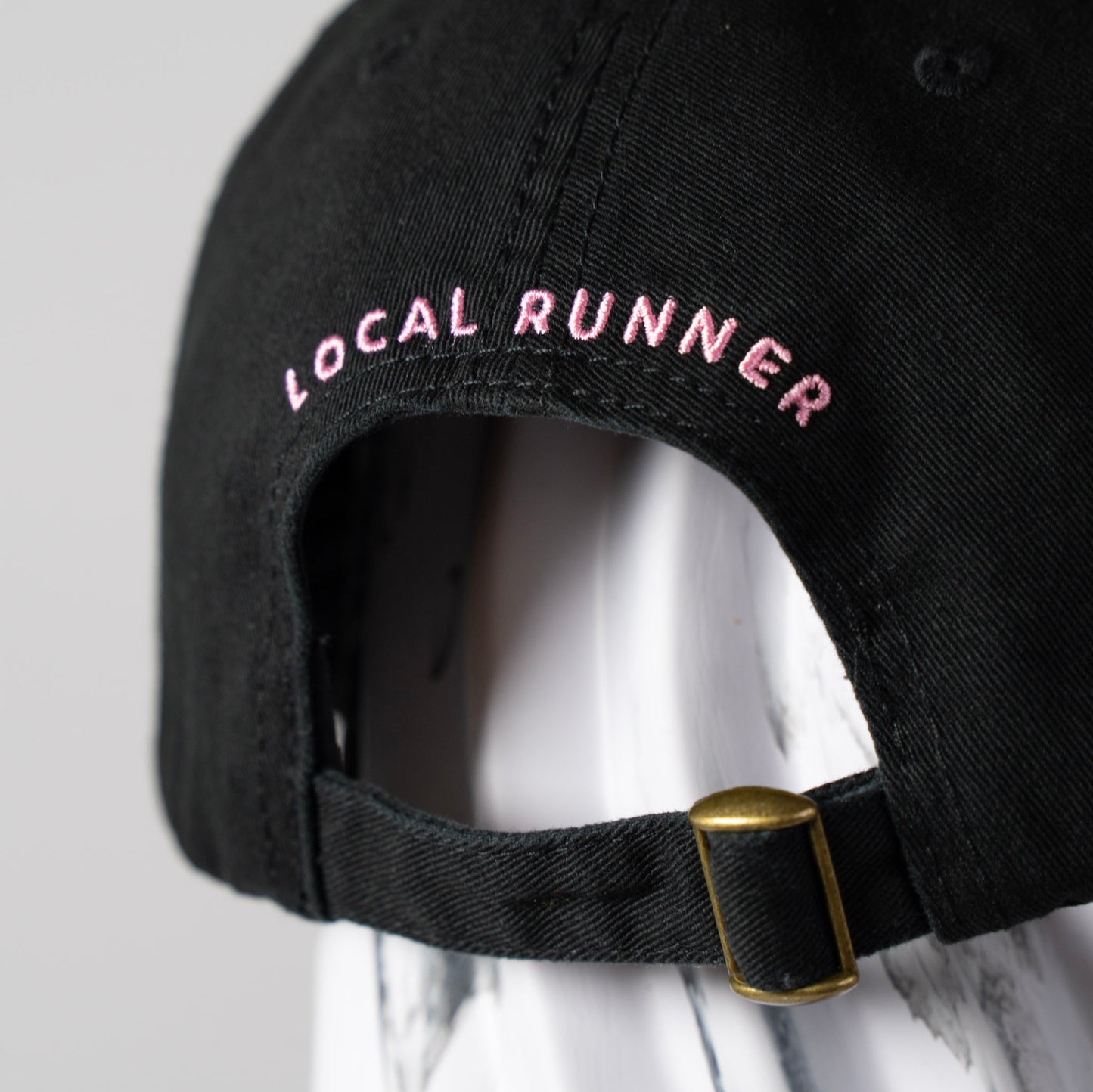 A Black cap with 'LOCAL RUNNER' embroidery
