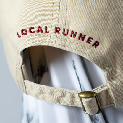 A Beige cap with 'LOCAL RUNNER' embroidery